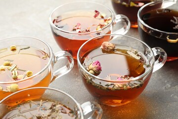 Aromatic herbal tea in glass cups on grey table, closeup