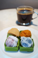 Tasty Khanom Tom and Sticky Rice with Sweet Toppings, Popular Thai Traditional Dessert with Aromatic Black Coffee