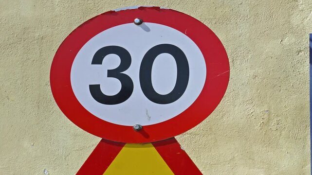  zooming in on a  30 mph or 30 kph speed sign 