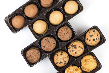 Various round cookies in an open box. Cookies in a pack on white
