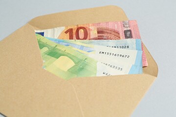 Money bonus. Envelope with euro banknotes on light grey background, closeup