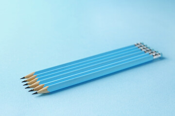 Graphite pencils on light blue background, closeup