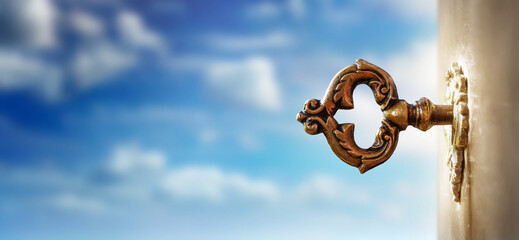 An old key in a keyhole on the background of an sky, macro photography. Retro style. The key to knowledge. Concept and idea for history, education, business, security, secret background.