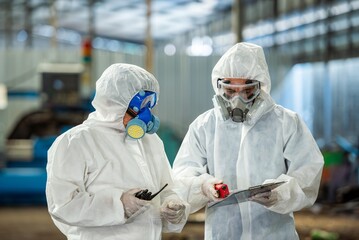 Male inspector team investigate danger chemical gas leak spill with safety face mask PPE suit in area closed barricade security tape. danger dirty area infected chemical leak spill cross stripe ribbon