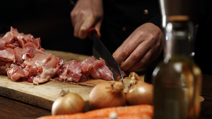 Female Chef Cutting Chicken Thighs with Knife.