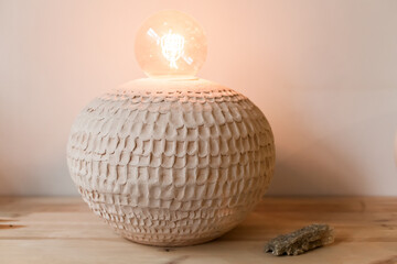 Artisanal ceramic home decor in a minimalist showroom. Handcrafted vases, candle holders, and tableware in earth tones. Includes Easter-themed ceramics and in-store workshop scenes