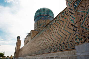 Ancient Islamic mausoleum in Samarkand with large turquoise dome and traditional ornamental...
