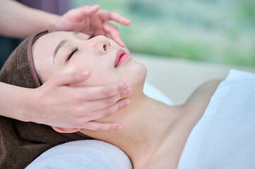 Asian Woman Receiving Facial Massage at Spa, Relaxation and Skincare Treatment