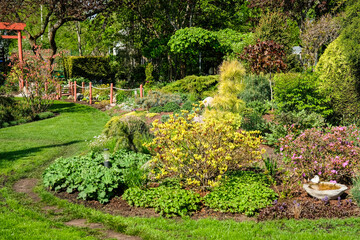A vibrant, well-maintained ornamental Lush Flower Garden with Decorative Rock and Mulch. Ideal image for themes related to landscaping, gardening, backyard design, and nature aesthetics.