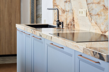 A Modern Kitchen Featuring a Sleek and Stylish Marble Countertop Accompanied by Blue Cabinets