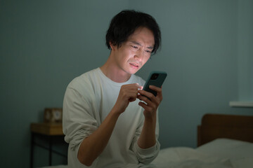 男性　スマートフォン　スマホ　ベッド