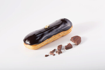 Gourmet Chocolate Eclair with Gold Leaf and Chocolate Shavings on White
