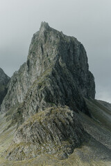Steep rocky peak of Eystrahorn mountain in East Iceland under overcast sky...