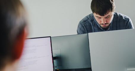 Team of male developers work code control robotics system and software automation project write...