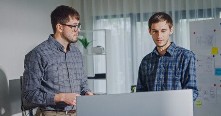 Team adult male engineer collaborate on robotic hand project using AI code solutions machine learning at tech workspace. Artificial intelligence interface, collaboration support prototype development.