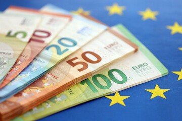 European eur currency money bills on Euro union blue flag close up