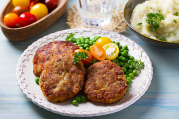 Fish cakes with green peas. Fish patties or burgers. View from above, top studio shot