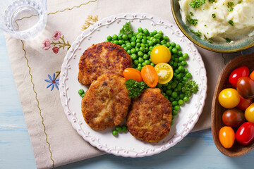 Fish cakes with green peas. Fish patties or burgers. View from above, top studio shot