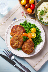 Fish cakes with green peas. Fish patties or burgers. View from above, top studio shot