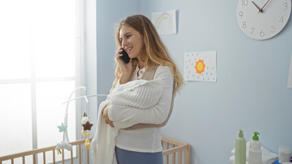 Woman talking on phone holding baby in cozy bedroom with cradle and decorative nursery details,...