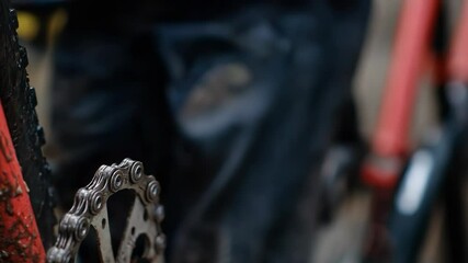 A close-up of a muddy hand gripping a bicycle chain, showcasing the intricacies of bike maintenance and the passion for cycling, capturing the essence of outdoor adventures and mec