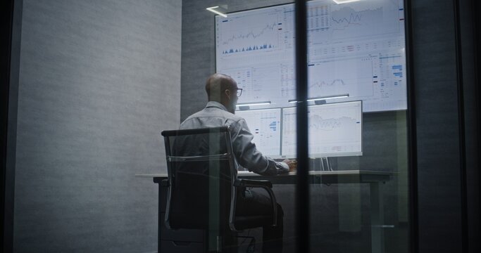 Financial Analyst Suffering from Financial Crisis, Yelling in Phone, Analyzing Exchange Market Charts in Office at Night. African American Businessman Furious About Sudden Stock Market Collapse. - Powered by Adobe
