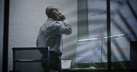 Stock Exchange Broker Shouting in Phone, Soaking Financial Loss, Monitoring Real-Time Stocks, Exchange Market Charts in Office at Night. African American Investment Agent Angry About Bad Economy News.