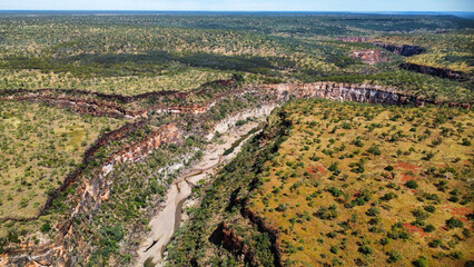 A calm creek flowing through a canyon in the Australian outback, seen from above
