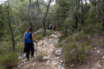 Obraz premium Group of hikers hiking in a nature trail. People trekking outdoors. Active healthy lifestyle