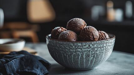 On the table are homemade chocolate ice cream balls in a cream basin.