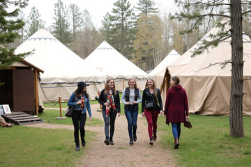 Women Strolling Through a Serene Glamping Site Amidst Nature
