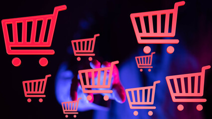 E-commerce concept.  Person interacts with virtual shopping carts.  Buy online.