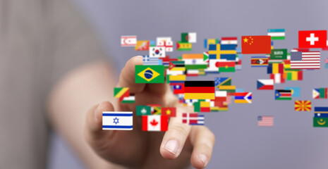 Image of a hand interacting with a digital display of world flags, representing global...