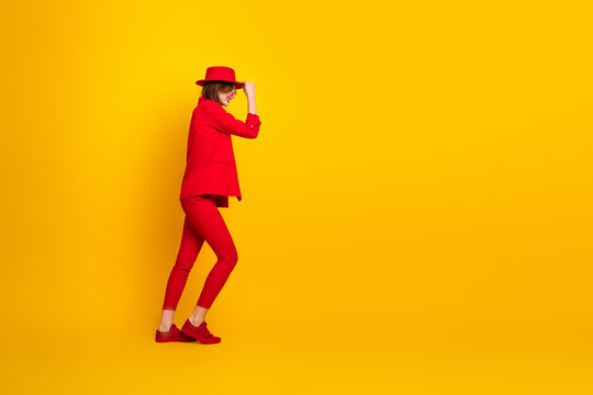 Young woman in a striking red outfit posing against a vibrant yellow background showcasing style and elegance