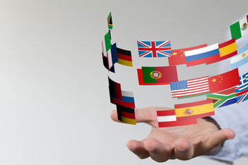 Image of a hand holding various national flags, symbolizing international relations and global...