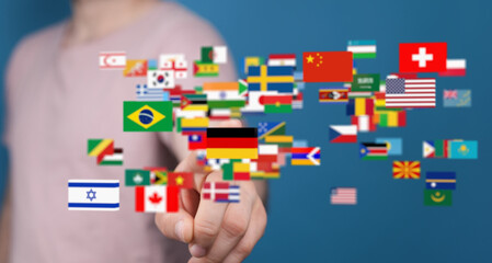 A person interacts with a digital display of world flags, symbolizing global communication and...