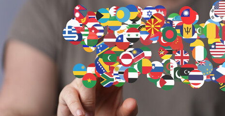 Person interacts with a digital display of world flags, symbolizing global connection and...