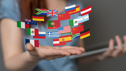 Image of a hand holding various national flags, representing global communication and international...