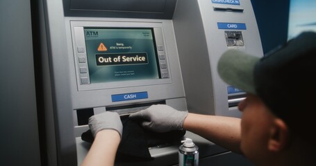 Cleaning Service: Professional Cleaner Wiping Out of Service ATM with Microfiber Rag, Cleaning Away Dirt and Dust, Preparing Automated Teller Machine, Cash Machine for Using. Public Banking Equipment.