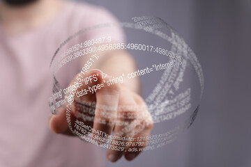 Close-up of a hand interacting with a 3D holographic display of code, showcasing digital technology.
