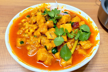 Vibrant Tomato-Based Curry Dish with Fresh Herbs and Savory Meat or Vegetable Bites