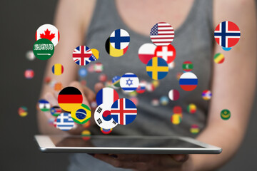 Image of a person using a tablet, surrounded by various country flags, representing global...