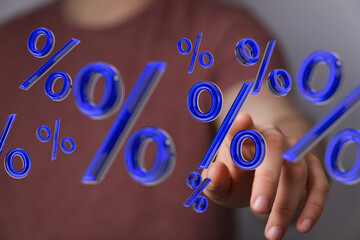 Hand interacting with 3D percentage symbols.  Finance, interest, growth, investment.