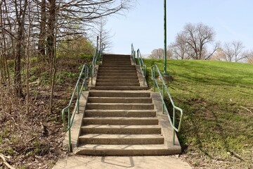 In front of the stairs going up in the park.