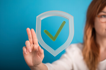 Woman displays a digital shield with a checkmark, symbolizing secure data and online protection.