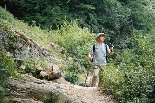 asian vloger shooting whild hike
