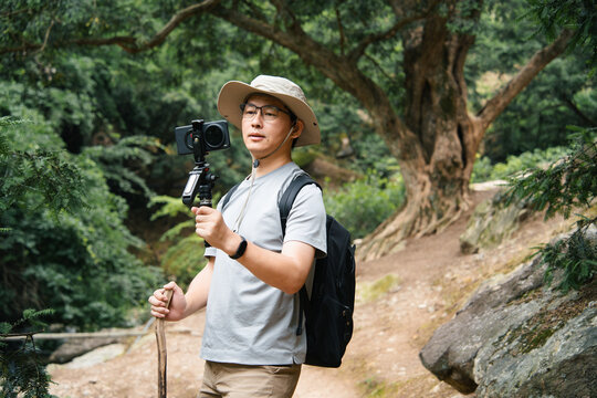 asian vloger shooting whild hike