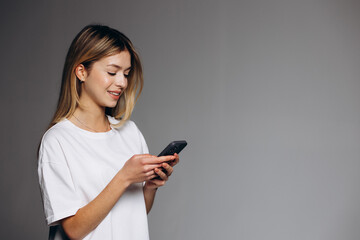 Fototapeta premium Young woman using mobile phone isolated on background