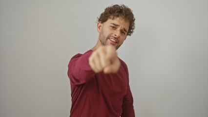 Young man pointing directly at viewer with determined expression isolated on white background...