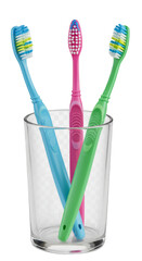 Toothbrushes In A Clear Glass With Blue Green And Pink Color Brushes Isolated Photo